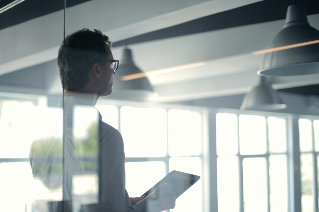 A stock image: displaying a man with a tablet looking into the distance.